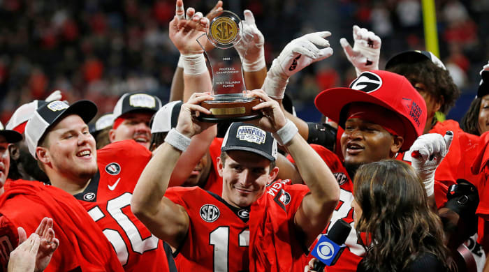 Georgia quarterback Stetson Bennett raises the SEC Championship MVP trophy after a victory against LSU.